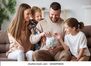 Happy family: cheerful mother and father with kids smiling and putting coins into piggy bank while sitting on sofa at home
 - Powered by Shutterstock