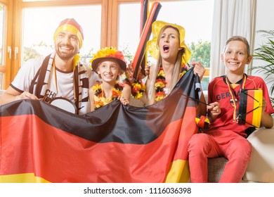 Happy Family Cheering For The German Soccer Team In Front Of TV