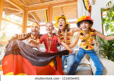 Happy Family Cheering For The German Soccer Team In Front Of TV