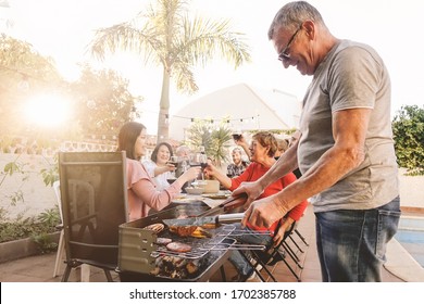 Happy Family Cheering And Toasting With Red Wine In Barbecue Party - Chef Senior Man Grilling Meat And Having Fun With Parents - Weekend Food Bbq And Reunion Young And Older People Lifestyle Concept