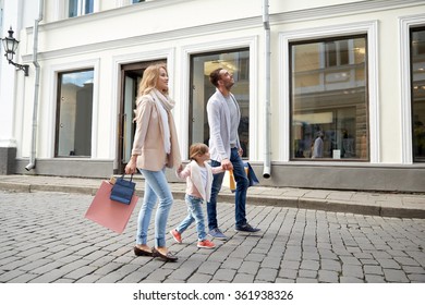 Happy Family With Child And Shopping Bags In City