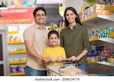 Happy Family With Child And Shopping Cart Buying Food At Grocery Store Or Supermarket