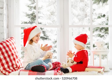 Happy Family Children Brother And Sister Laughing And Sitting On The Winter Window Christmas