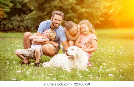 Happy Family With Children And Dog In Summer In The Garden