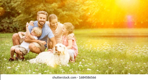 Happy Family With Children And Dog Together In The Garden In Summer
