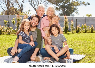 Happy family with children and grandparents in the garden in summer