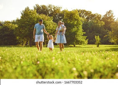 Happy Family With Children In The Park At Sunset.