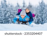 Happy family, children sledding in winter. Winter active sports fun outdoors. Wonderful winter landscape background.