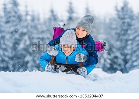 Happy family, children sledding in winter. Winter active sports fun outdoors. Wonderful winter landscape background.