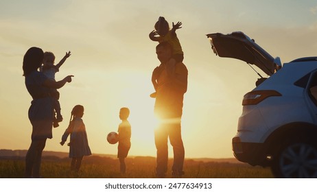 happy family. children stand together next to the car silhouette of the sunset in the park. family dream concept. happy family standing with sunlight, back watching journey travel in the park - Powered by Shutterstock