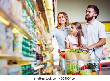 Happy Family Choosing Dairy Products In Supermarket