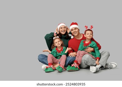 Happy family in Christmas clothes on grey background - Powered by Shutterstock