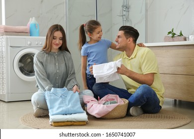 Happy Family With Clean Laundry In Bathroom