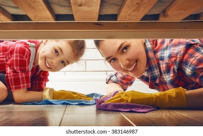 Happy family cleans the room. Mother and daughter do the cleaning in the house. A young woman and a little child girl wiped the floor. - Powered by Shutterstock