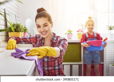 Happy Family Cleans The Room. Mother And Daughter Do The Cleaning In The House. A Young Woman And A Little Child Girl Dusting.