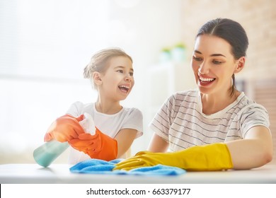 Happy family cleans the room. Mother and daughter do the cleaning in the house. A young woman and child girl are dusting. Cute little helper. - Powered by Shutterstock