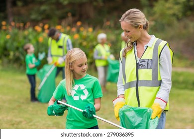 Happy Family Collecting Rubbish On A Sunny Day