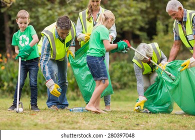 Happy Family Collecting Rubbish On A Sunny Day