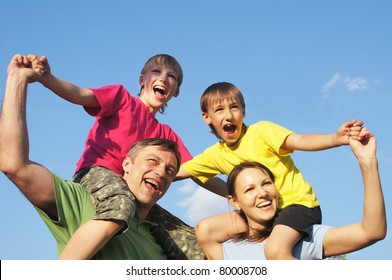 Happy Family In Color Clothes At Nature