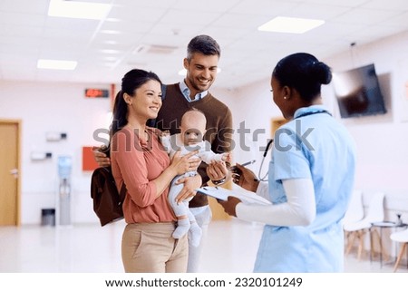 Happy family communicating with African American pediatric nurse in waiting room of a medical clinic.