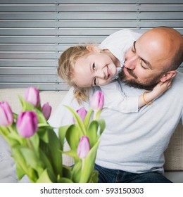 Happy family concept, father and daughter portrait, sitting on a couch having fun. Gender stereotyping, gender roles, equality issue. Stay at home dad.