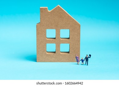 Happy family concept: Miniatures family model on a wooden house - Shutterstock ID 1602664942