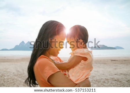 Happy family concept, Young mother jolly with her baby at the beach