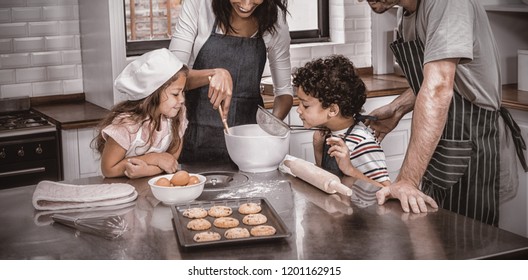 Happy Family Cooking Biscuits Together In Kitchen At Home