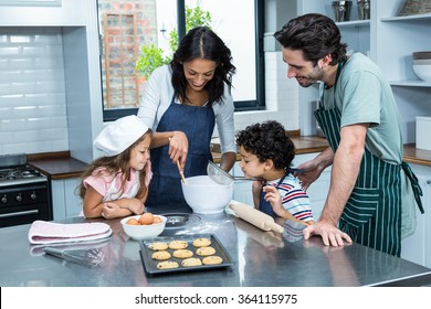 Happy family cooking biscuits together in kitchen at home. Social distancing and self isolation in quarantine lockdown for Coronavirus Covid19
