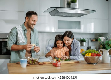 Happy family cooking together in kitchen.They are preparing healthy food together in the kitchen. - Powered by Shutterstock