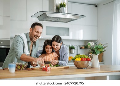Happy family cooking together in kitchen.They are preparing healthy food together in the kitchen. - Powered by Shutterstock