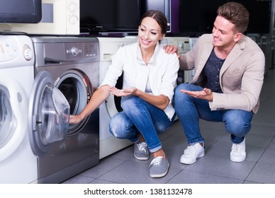 Happy Family Couple Buying New Clothes Washer In Supermarket