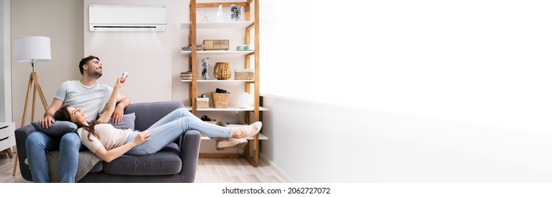 Happy Family Couple Using Air Conditioner. Apartment AC