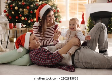 Happy family with cute baby on floor in room decorated for Christmas - Powered by Shutterstock