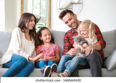 Happy Family With Cute Cat Resting At Home