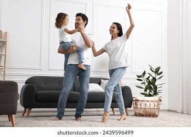 Happy family dancing and having fun in living room, low angle view - Powered by Shutterstock