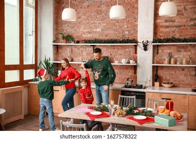 Happy Family Dancing On Christmas Eve In Kitchen