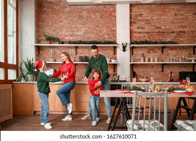 Happy Family Dancing On Christmas Eve In Kitchen