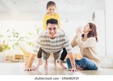 Happy family with daughter playing at home - Shutterstock ID 1906482919