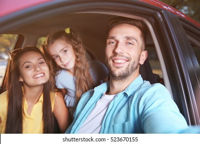 Happy Family With Daughter Taking Selfie In Car