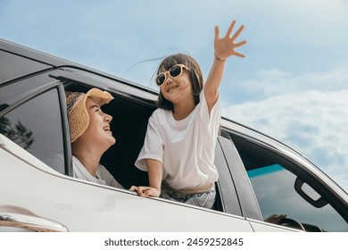 Happy family day. Asian Dad, mom and daughter little kid smiling sitting in compact car windows raise hand wave goodbye, Summer at beach, Car insurance, Family holiday vacation travel, road trip - Powered by Shutterstock