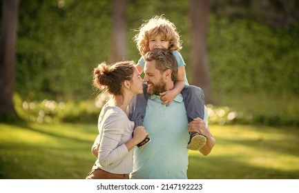 Happy Family Day. Mother And Father Carrying Son On Shoulders. Family Day. Parents And Boy Child