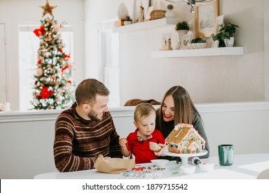 Happy Family Decorating A Christmas Gingerbread House At Home