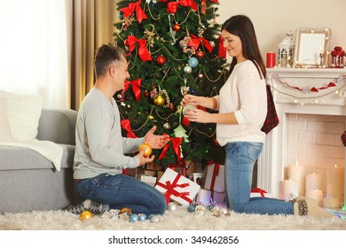 Happy family decorating Christmas tree in holiday living room