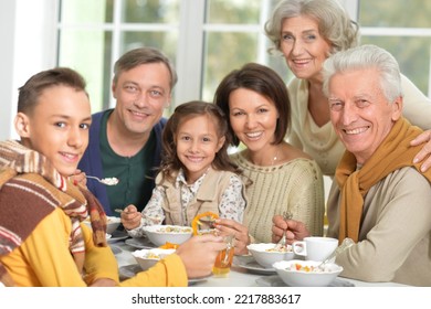 Happy Family Of Different Generations Eating Together In The Kitchen