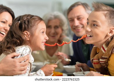 Happy Family Of Different Generations Eating Together In The Kitchen