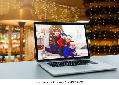 Happy Family Display Laptop By A Fireplace On Table. Notebook Computers