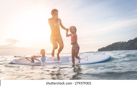 Happy Family Diving In The Water. Mom And Daughter Jumping From The Surf.concept About Vacation, Family And People