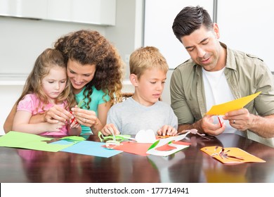 Happy Family Doing Arts And Crafts Together At The Table At Home In Kitchen