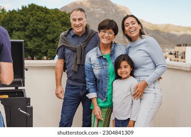 Happy family doing barbecue dinner at house terrace rooftop during summer time - Multi generational people smiling on camera outdoor - Powered by Shutterstock